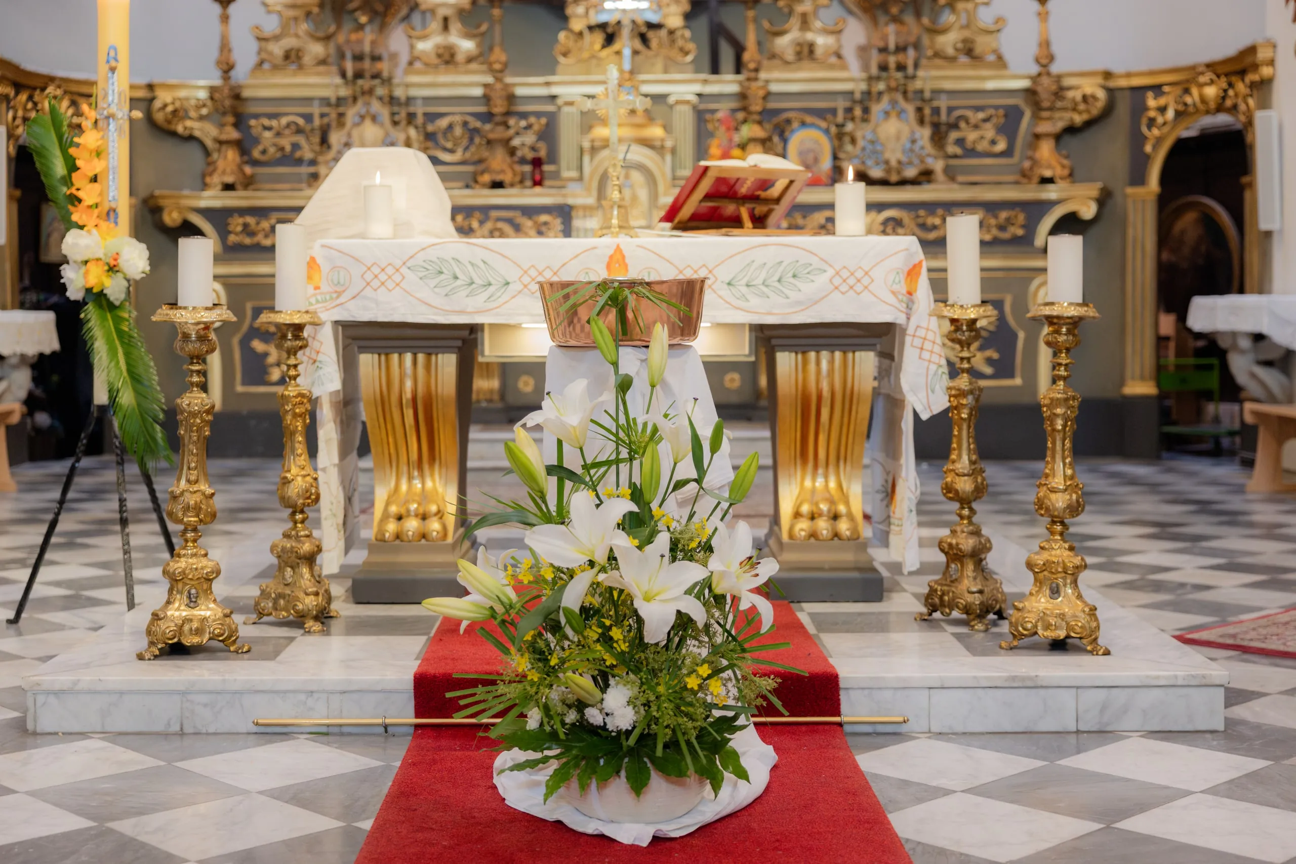 L'autel de l'église et son grand bouquet de lys blancs, posé sur le tapis rouge