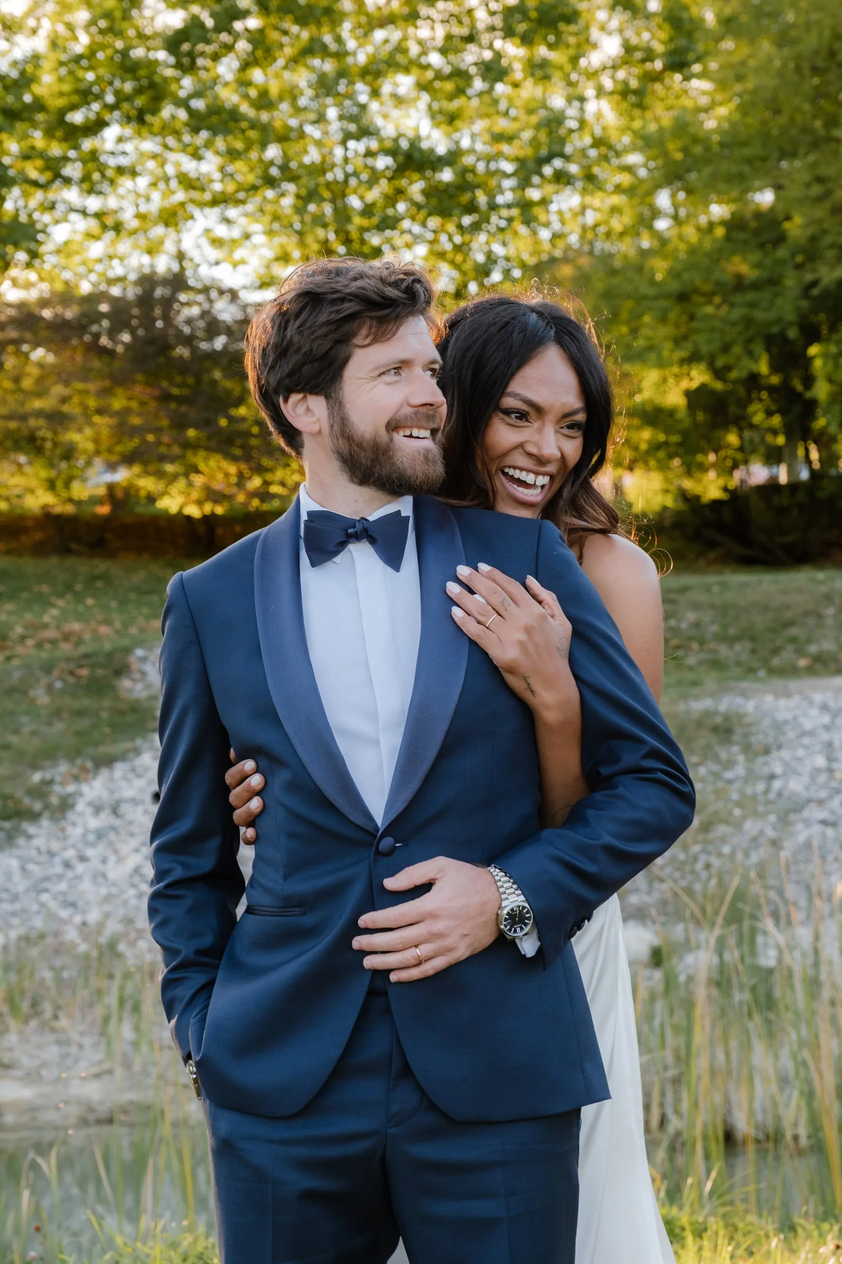 Le marié en smoking bleu nuit, la mariée dans son dos